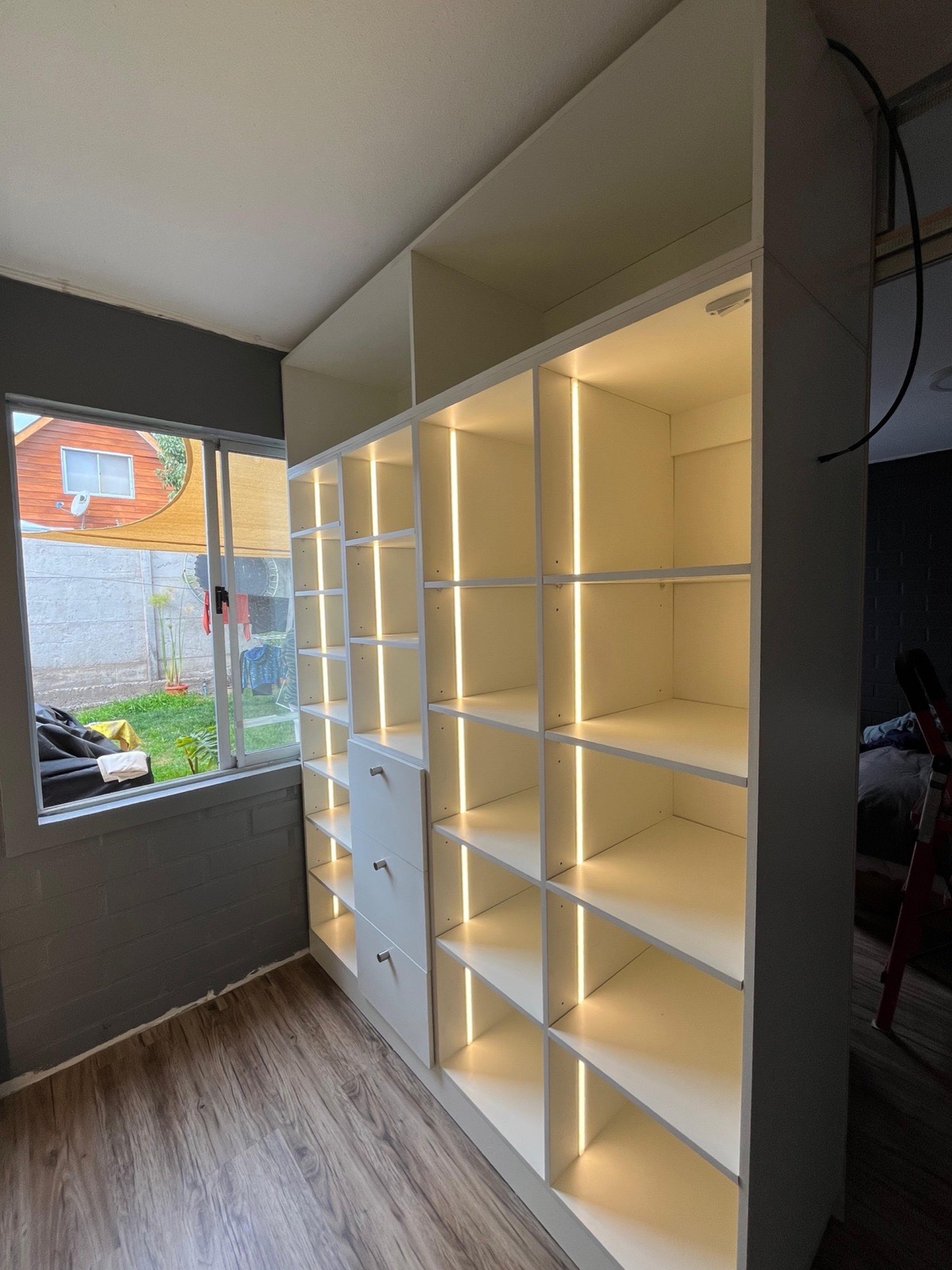 Walk-in closet con cajones y repisas con iluminación Led.