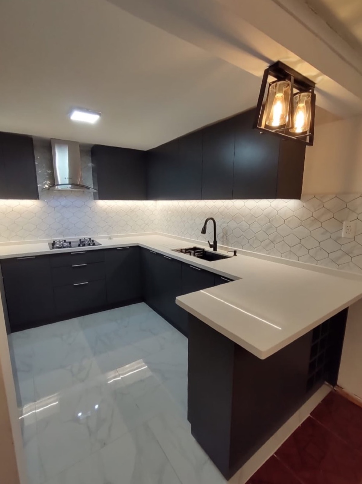 Cocina en U color berenjena con revestimiento hexagonal blanco y cubierta clara