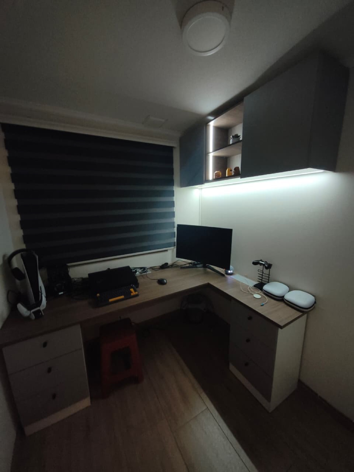 Escritorio en L. Muebles aéreos con iluminación Led y cubierta con enchufe plegable.