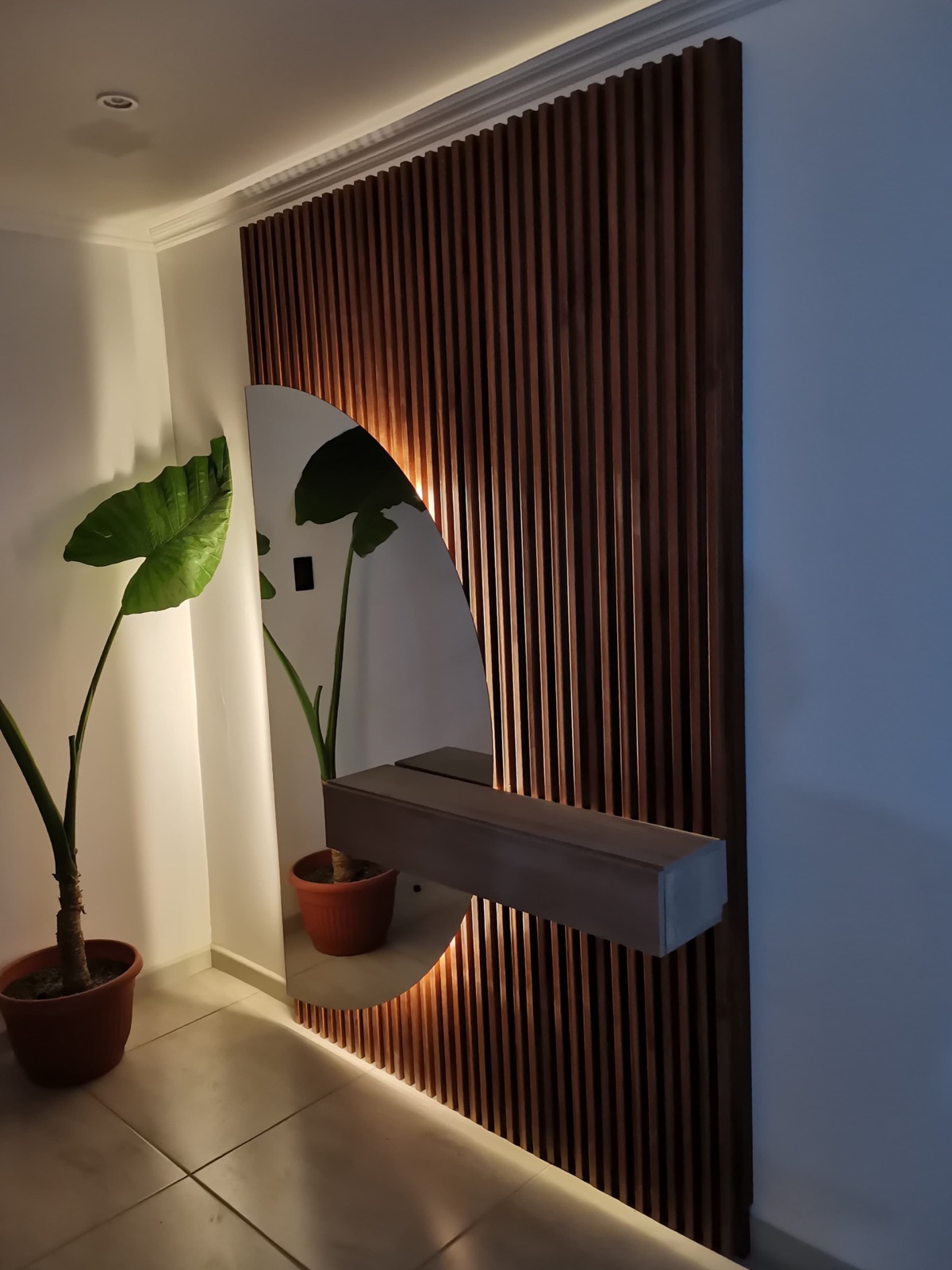 Hall entrada con wall panel decorativo, espejo media luna y mueble aéreo.