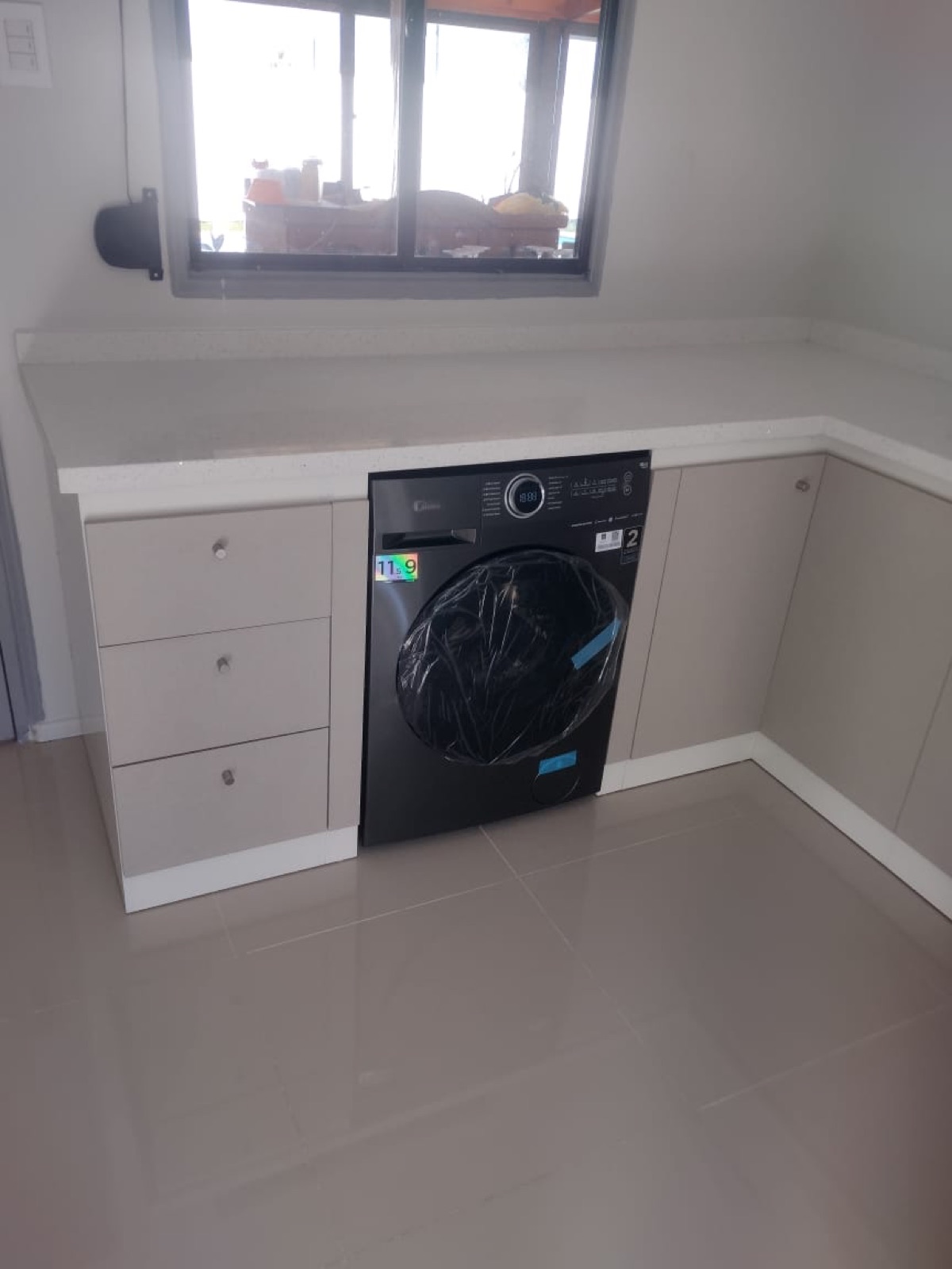 Logia con instalación de lavadora bajo cubierta.